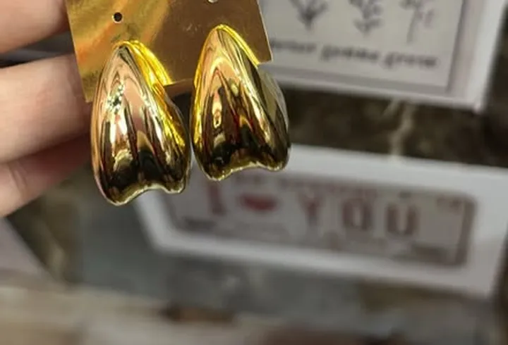 Elora's chunky gold dome drop earrings on a card